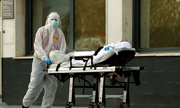 Un técnico sanitario traslada a un paciente al Hospital. | EFE