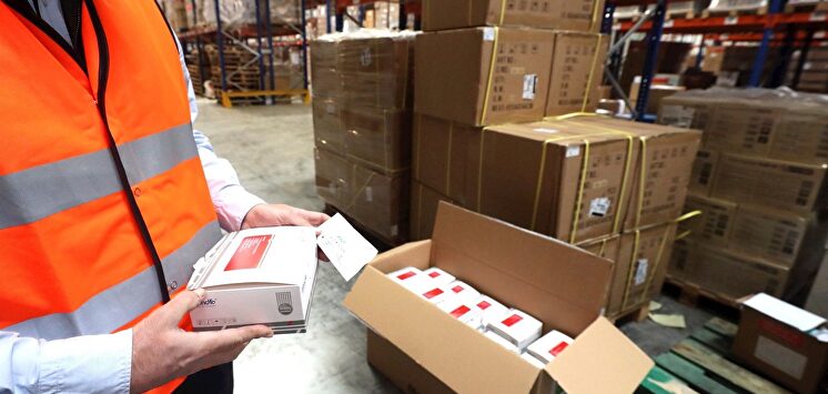 Operario con cajas de test de coronavirus | EFE