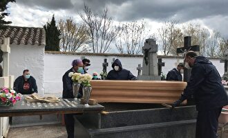 Operarios proceden a enterrar un féretro en el cementerio de Aldea del Rey, Ciudad Real. | EFE