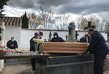 Operarios proceden a enterrar un féretro en el cementerio de Aldea del Rey, Ciudad Real. | EFE