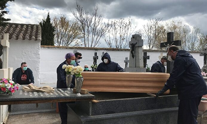 Operarios proceden a enterrar un féretro en el cementerio de Aldea del Rey, Ciudad Real. | EFE