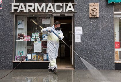 Labores de desinfección frente a una farmacia. | EFE