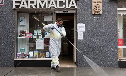 Labores de desinfección frente a una farmacia. | EFE