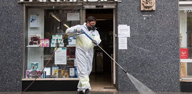 Labores de desinfección frente a una farmacia. | EFE