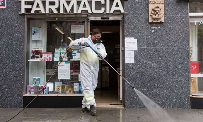 Labores de desinfección frente a una farmacia. | EFE