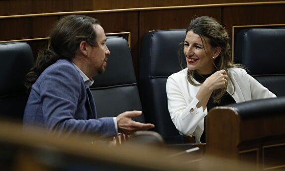 La ministra de Trabajo, Yolanda Diaz, habla con Pablo Iglesias, este jueves en el Congreso de los Diputados. | EFE