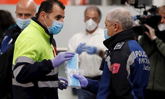 Policías entregan mascarillas en la estación de metro de Nuevos Ministerios en Madrid. | EFE
