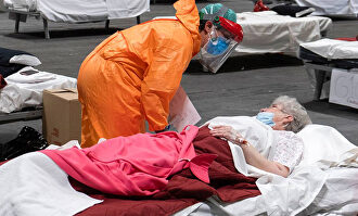 Sanitario atendiendo a una paciente de Covid durante el pico de la pandemia | Satse