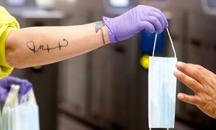 Distribución de mascarillas en el transporte público. | EFE