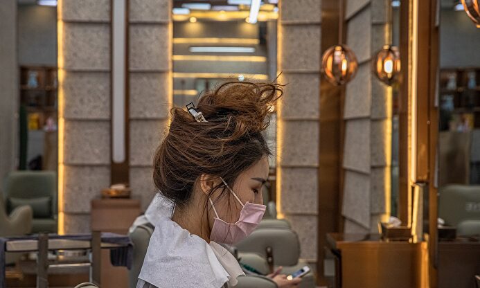 Una chica en la peluquería con mascarilla | EFE