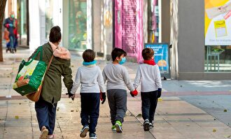 Una madre y sus hijos tras hacer la compra en Zaragoza | EFE