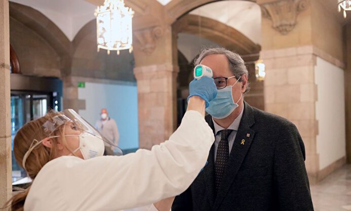 Quim Torra mientras le toman la temperatura en el Parlamento | EFE