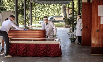 Operarios del cementerio municipal de València y miembros de una funeraria introducen un féretro en la sala de ceremonias del crematorio | EFE