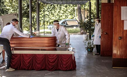 Operarios del cementerio municipal de València y miembros de una funeraria introducen un féretro en la sala de ceremonias del crematorio | EFE