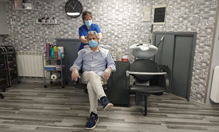 Una peluquera lava la cabeza con las debidas precauciones sanitarias (Madrid, Collado Villalba) | LD