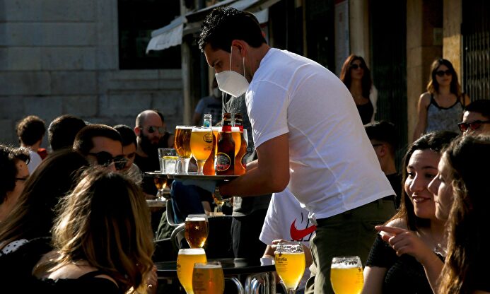 Un camarero sirve a sus clientes en un bar. | EFE