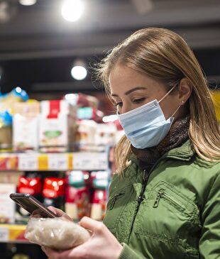 Imagen de una mujer con mascarilla en un supermercado. | Ayuntamiento de Las Rozas