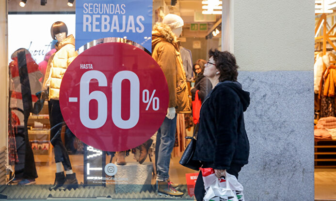 Una mujer pasea junto a una tienda de moda de Madrid con rebajas. | Europa Press