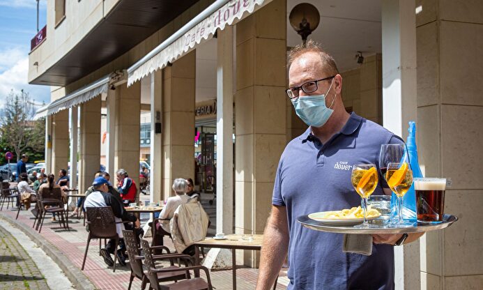 Un camarero atiende a los clientes en la terraza tras la reapertura del establecimiento. | EFE