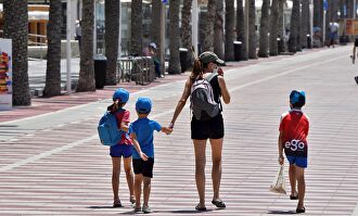 Una mujer con tres niños pasean este viernes por Almería. | EFE