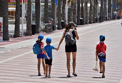 Una mujer con tres niños pasean este viernes por Almería. | EFE