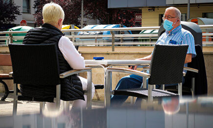 Dos personas en una terraza con mascarillas. | EFE