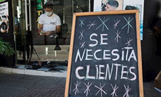 Cartel con el mensaje "Se necesita clientes", en una barbería de la Zona Colonial, en Santo Domingo (República Dominicana). | EFE