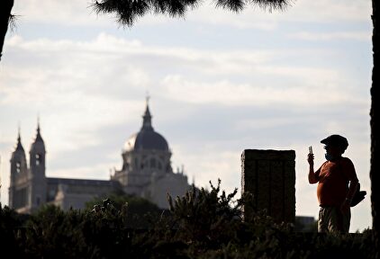 Un hombre toma una fotografía en su paseo matinal por Madrid Río este lunes, primera jornada del paso a la fase 1 de Madrid. | EFE