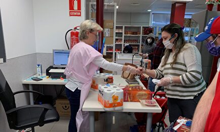Clientes y voluntarios de Cáritas, en el economato que esta organización tiene en el distrito madrileño de Tetuán. | EFE