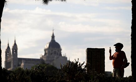 Un hombre toma una fotografía en su paseo matinal por Madrid Río este lunes, primera jornada del paso a la fase 1 de Madrid. | EFE