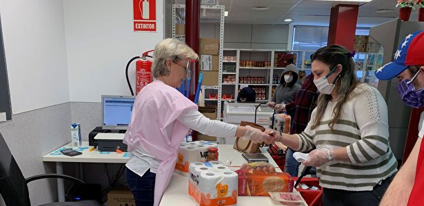 Clientes y voluntarios de Cáritas, en el economato que esta organización tiene en el distrito madrileño de Tetuán. | EFE