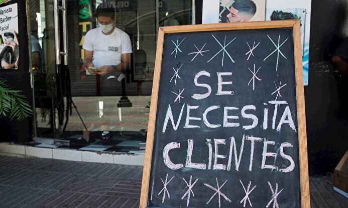 Cartel con el mensaje "Se necesita clientes", en una barbería de la Zona Colonial, en Santo Domingo (República Dominicana). | EFE