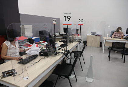 Dos trabajadoras de la Oficina del Empleador protegida con mascarilla y con una pantalla separador | Europa Press
