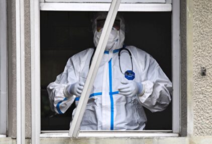 Un sanitario tapado con mascarilla y traje de protección contra el coronavirus en un hospital. | EFE