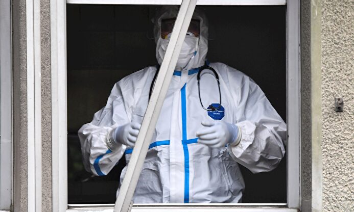 Un sanitario tapado con mascarilla y traje de protección contra el coronavirus en un hospital. | EFE