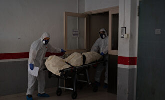 Operarios trasladan el cadáver de un anciano. | David Zorrakino (Europa Press)