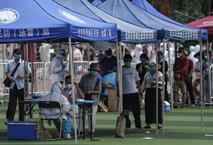 Residentes o gente que visitó el mercado de Xinfadi hacen cola para hacerse el test de coronavirus | EFE