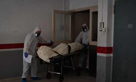 Operarios trasladan el cadáver de un anciano. | David Zorrakino (Europa Press)