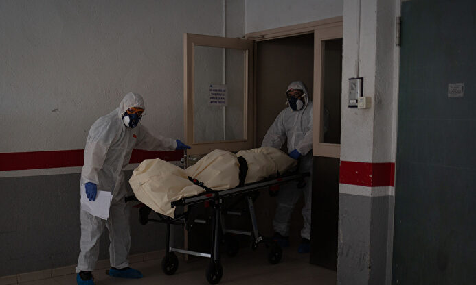 Operarios trasladan el cadáver de un anciano. | EFE