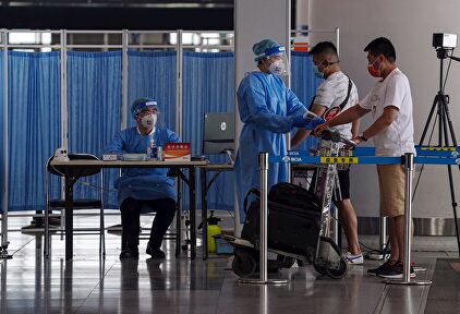 Personal de seguridad hace la prueba del coronavirus a pasajeros este miércoles en Pekín | EFE