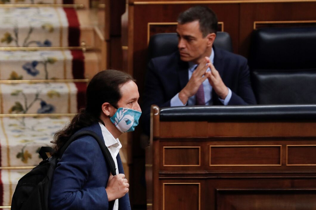 Pablo Iglesias pasa por delante de un indiferente Pedro Sánchez. | EFE