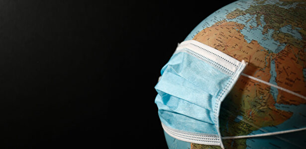 Una bola del mundo con una mascarilla quirúrgica | Óscar J.Barroso / Europa Press
