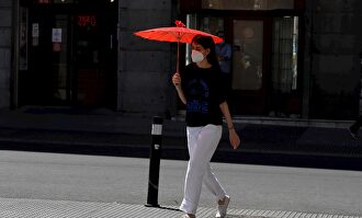 Una viandante se protege del sol con una sombrilla en el centro de Madrid este lunes | Europa Press
