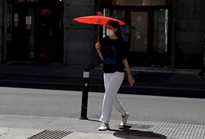 Una viandante se protege del sol con una sombrilla en el centro de Madrid este lunes | Europa Press