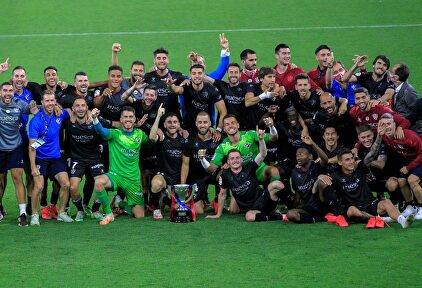 Los jugadores del Huesca posan con el trofeo de campeones de LaLiga SmartBank sobre el césped de El Molinón. | EFE