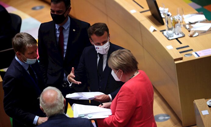 Sanchez escucha y parece unirse a una de las conversaciones entre Enmanuele Macron y Angela Merkel. | EFE