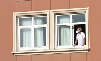 El jugador del Fuenlabrada, Chico Flores, se asoma a una ventana del hotel Finisterre donde permanecen confinados. | EFE