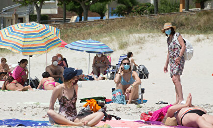 Varias personas protegidas con mascarillas toman el sol en la Playa de A Rapadoira en Foz, en la comarca de A Mariña, Lugo | Carlos Castro / Europa Press