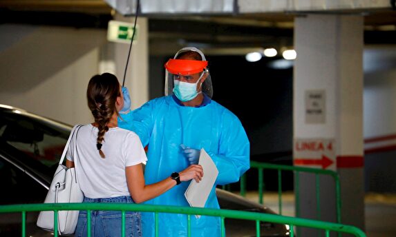 Un sanitario efectúa una prueba a una posible paciente | EFE