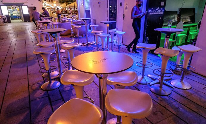 Varias personas apuran los minutos antes del cierre de un bar en Ibiza. | EFE